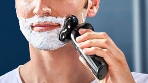 hombre usando maquina afeitar philips