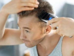 hombre usando una máquina de afeitar con aspiración de pelos