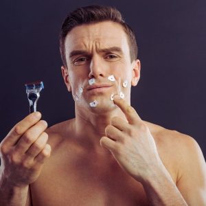 hombre joven usando productos para después del afeitado