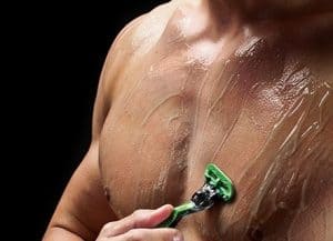 hombre depilándose el pecho con una cuchilla y gel